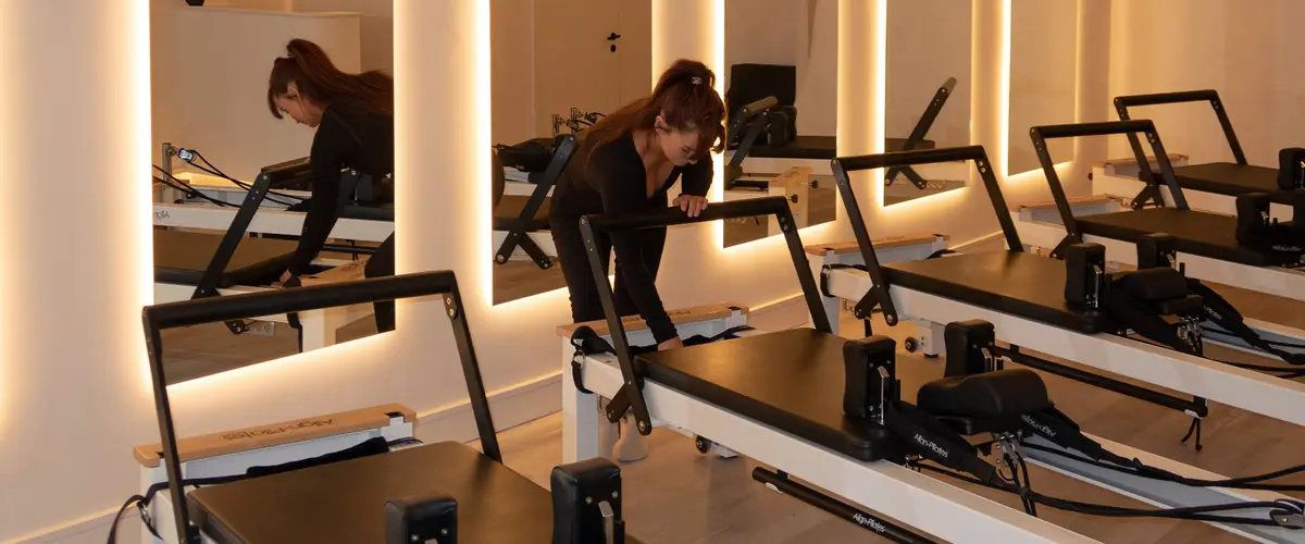 A Flexii client working on a reformer in the warmly lit studio