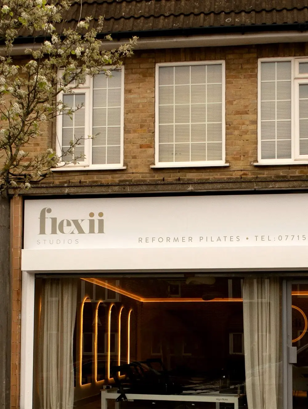 The Flexii Studios shopfront on London Colney High Street, with the studio lights glowing inside